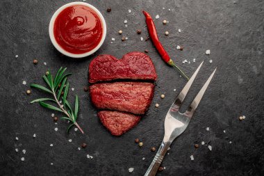 Siyah arka planda baharatlı dilimlenmiş biftek. 
