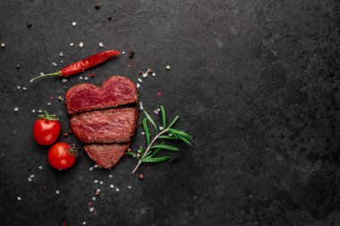Siyah arka planda baharatlı dilimlenmiş biftek. 