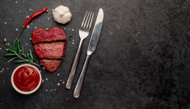 Siyah arka planda baharatlı dilimlenmiş biftek. 