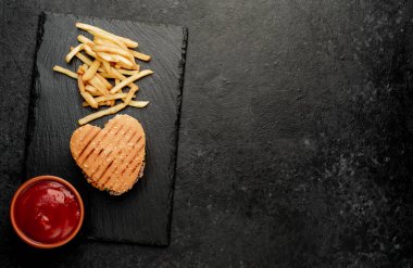 Etli taze sandviç, siyah taş arka planda kızarmış burger.