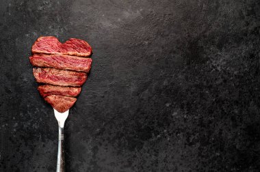 Siyah arka planda dilimlenmiş biftek. 