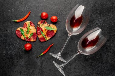 Kalp şeklinde pizza dilimleri siyah taş arka planda