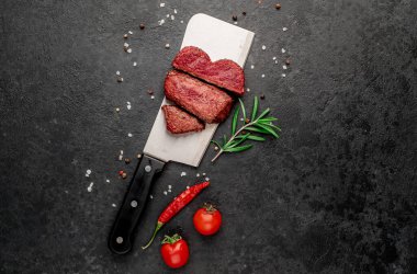 Siyah arka planda baharatlı dilimlenmiş biftek. 