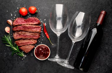 Siyah arka planda baharatlı dilimlenmiş biftek. 