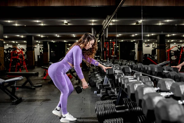 Spor Salonunda Dambıllarla Egzersiz Yapan Genç Bir Kadın — Stok fotoğraf