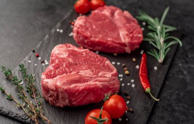 Siyah arka planda baharatlı dilimlenmiş biftek. 