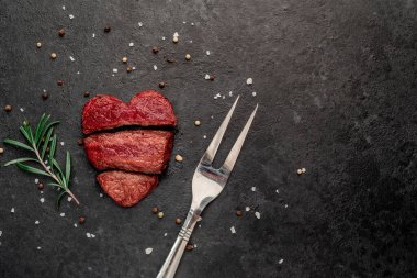 Siyah arka planda baharatlı dilimlenmiş biftek. 