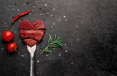 Siyah arka planda baharatlı dilimlenmiş biftek. 