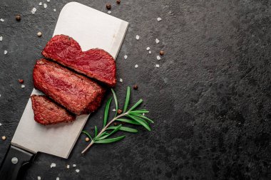 Siyah arka planda baharatlı dilimlenmiş biftek. 