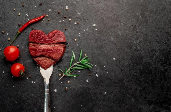 Siyah arka planda baharatlı dilimlenmiş biftek. 