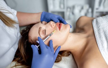 Güzellik uzmanı estetik ameliyat yapar. Kadın yüz masajı yaptırıyor