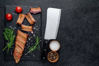 Izgara domuz pirzolası, yanında bıçak ve yemek malzemeleri. 