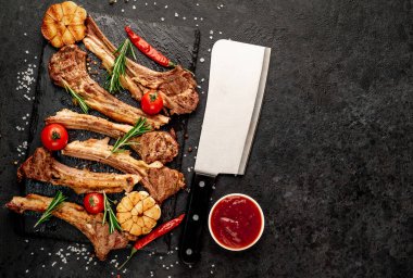 Izgara kaburga eti ve siyah yüzey üzerinde bıçak.