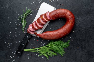 Bıçak ve otlarla servis edilen taze salam.