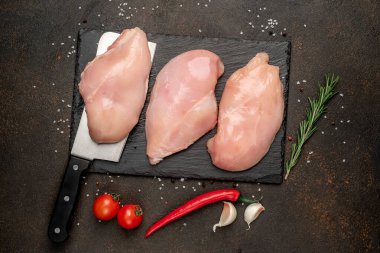 Çiğ tavuk filetosu, malzeme ve bıçak.