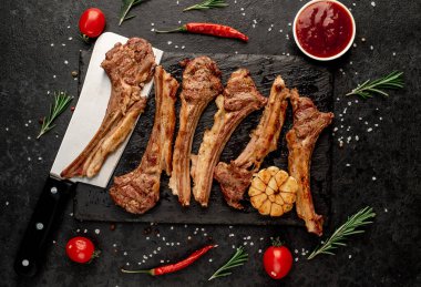 Izgara kaburga eti, malzeme ve siyah yüzey üzerinde bıçak.