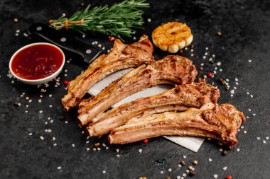 Izgara kaburga eti ve siyah yüzey üzerinde bıçak.