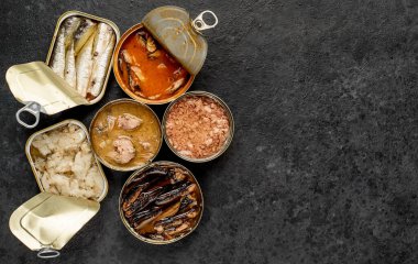 Siyah zemin üzerinde balıklar olan çeşitli açık kutuların üst görünümü