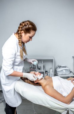 Genç bir kadın spa salonunda masaj yaptırıyor.