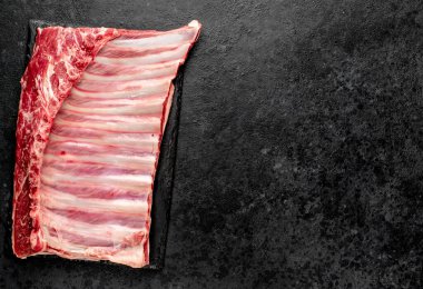 Siyah arka planda taze çiğ domuz pirzolası.