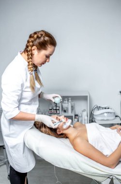 Genç bir kadın spa salonunda masaj yaptırıyor.