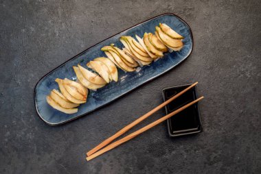 Yemek çubuklarıyla servis edilen suşi ruloları. 