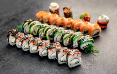 Sushi siyah taş arka planda yuvarlanıyor.