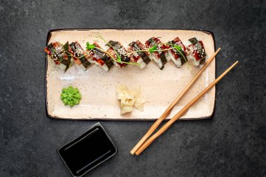 Yemek çubuklarıyla servis edilen suşi ruloları. 