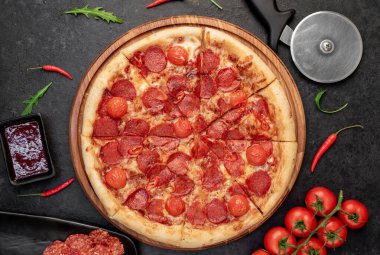 Siyah masa yüzeyinde malzemeleri olan pizza.