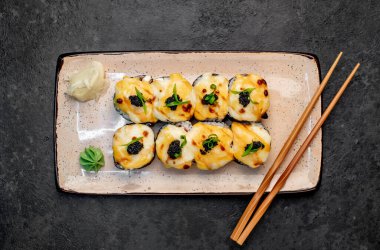 Yemek çubuklarıyla servis edilen suşi ruloları. 