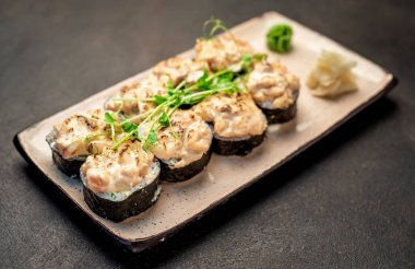 Karanlık masada servis edilen suşi ruloları.