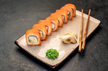 Yemek çubuklarıyla servis edilen suşi ruloları. 