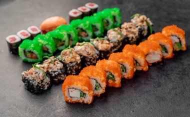 Sushi siyah taş arka planda yuvarlanıyor.