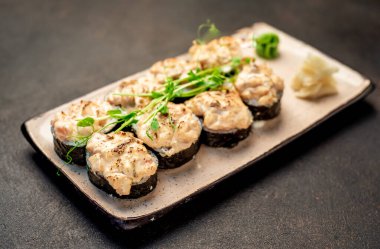 Karanlık masada servis edilen suşi ruloları.