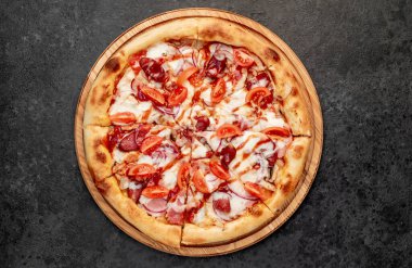 Siyah tahta yüzeyde lezzetli bir pizza.