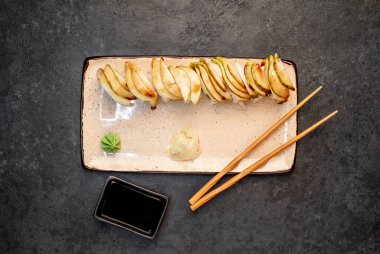 Yemek çubuklarıyla servis edilen suşi ruloları. 