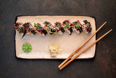 Yemek çubuklarıyla servis edilen suşi ruloları. 