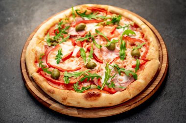 Siyah masa yüzeyinde lezzetli bir pizza.