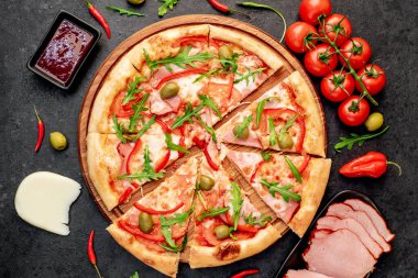 Siyah masa yüzeyinde malzemeleri olan pizza.