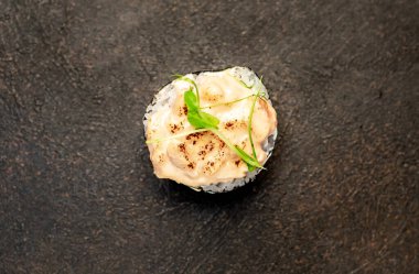 Suşi siyah tahta yüzeyde yuvarlanıyor.