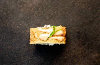 Suşi siyah tahta yüzeyde yuvarlanıyor.