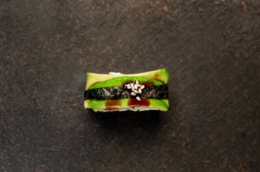 Suşi siyah tahta yüzeyde yuvarlanıyor.