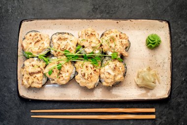 Yemek çubuklarıyla servis edilen suşi ruloları. 