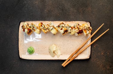 Yemek çubuklarıyla servis edilen suşi ruloları. 