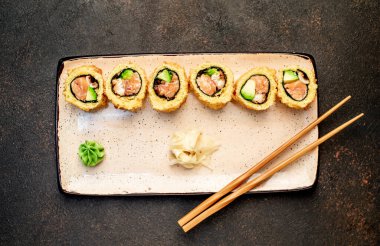 Yemek çubuklarıyla servis edilen suşi ruloları. 