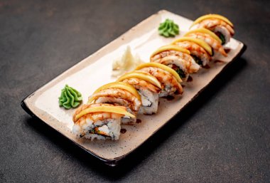 Karanlık masada servis edilen suşi ruloları.