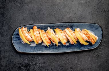 Karanlık masada servis edilen suşi ruloları.