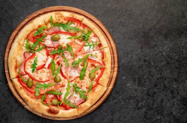 Siyah masa yüzeyinde lezzetli bir pizza.