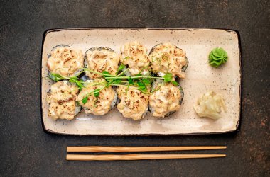 Yemek çubuklarıyla servis edilen suşi ruloları. 