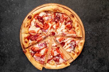 Siyah masa yüzeyinde lezzetli bir pizza.